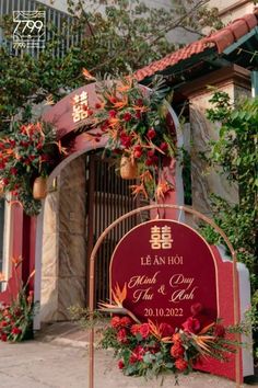 a red and gold wedding sign in front of a building that says le an hoi