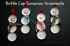 four snowmen made out of wine bottle caps with ribbons hanging from the top and bottom