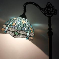 a lamp that is sitting on top of a table next to a light fixture with a dragonfly design on it