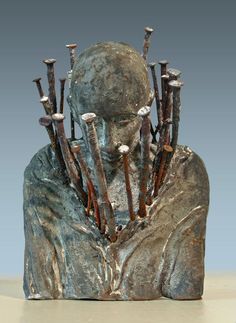 a sculpture of a man with lots of sticks in his head and hands behind him