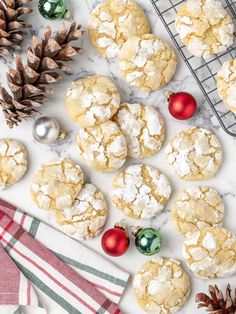 cookies with powdered sugar and christmas decorations on a cooling rack next to pine cones