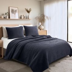 a bed in a bedroom with a blue comforter