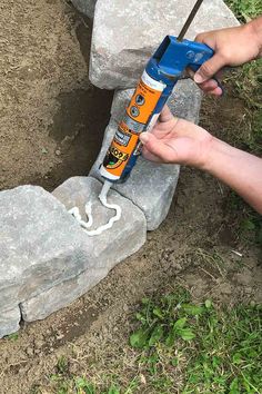 Applying adhesive to the stone Diy Stone Fire Pit, Diy Fire Pit Area, Make A Fire Pit, Backyard Homestead, Outdoor Fire Pit Area, Easy Fire Pit, Brick Fire Pit, Fire Pit Ring, Fire Pit Kit