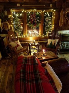 the living room is decorated for christmas with lights and plaid blankets on the couches