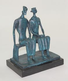 a statue of two people sitting on a bench