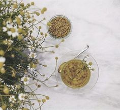 two bowls filled with food sitting on top of a table next to flowers and plants