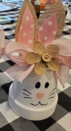 a close up of a cat shaped object on a checkered tablecloth with other items in the background