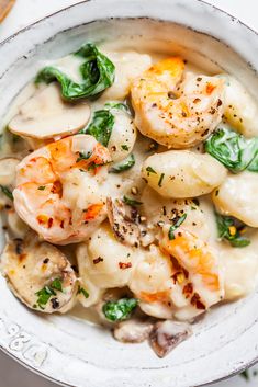 a white bowl filled with pasta and shrimp