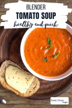 a bowl of tomato soup on a plate with bread and parmesan cheese next to it