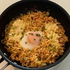 noodles and an egg are being cooked in a skillet