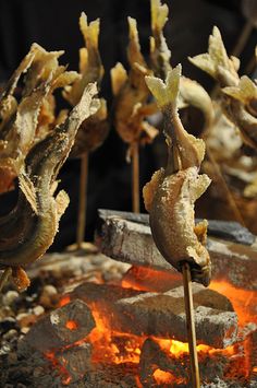 food being cooked on sticks over an open fire