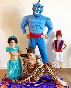 three children are dressed up in costumes and posing for a photo with an evil man