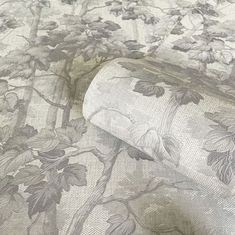 a roll of toilet paper sitting on top of a floral print wallpaper covered in vines and leaves