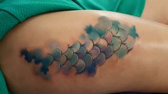 a woman's lower back with watercolor tattoos on her thighs and the bottom half of her stomach