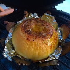 an onion sitting on top of foil covered grill