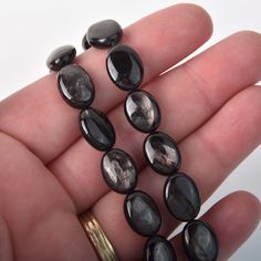 a person holding several black stones in their hand