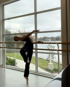 a person standing on one leg in front of a window