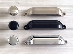 an assortment of metal handles and knobs on a wooden surface