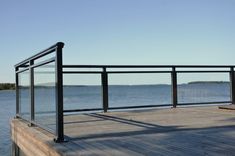 a wooden dock with glass railing overlooking the water