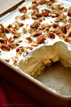 a cake in a pan with pecans and icing on the top, ready to be eaten