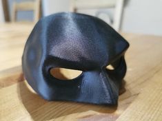 a black mask sitting on top of a wooden table