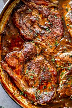 some meat in a pot with sauce and parsley on the side for garnish