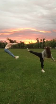 two people are doing yoga in a field at sunset with the sun setting behind them