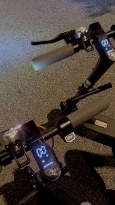 a close up of the handle bars on a bicycle with an alarm clock displayed at the front