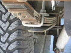 the front end of a truck with mud on it's tires and some screws