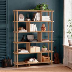 a bookshelf with various items on top of it in front of a blue wall