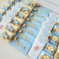 blue and gold baby shower decorations on display in a white box with ribbon around the edges