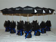 there are many black umbrellas that are on the table with blue ribbons around them