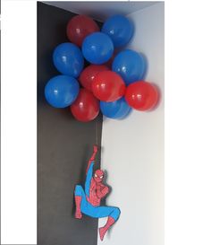 a spiderman hanging from the ceiling with balloons