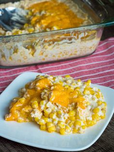 a white plate topped with food next to a casserole dish filled with corn