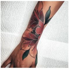 a woman's hand with a flower tattoo on it