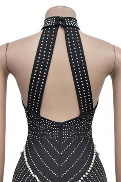 the back of a black and white dress with pearls on it's neckline