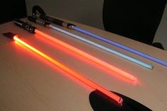 three different colored lights on top of a table next to some pens and pencils