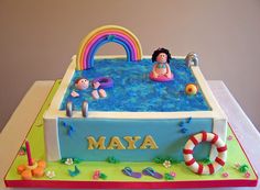 a birthday cake that is shaped like an inflatable pool with people and toys