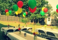 several tables set up for a party with balloons and flowers in vases on them