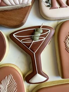 decorated cookies and cookie cutters on a table with icing in the shape of martini glasses