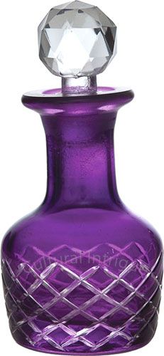 a purple glass bottle with a diamond on top