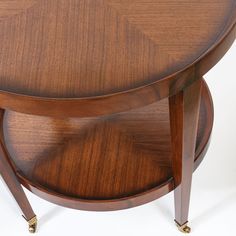 a round wooden table with two brass legs