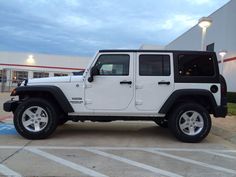 a white jeep parked in front of a building