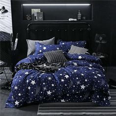 a bed with blue and white stars on the comforter, pillows and pillow cases