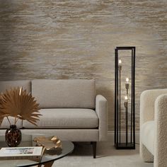 a living room scene with focus on the couch and chair, wallpapered in gold