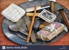 an assortment of kitchen utensils on a metal plate with napkins and spoons