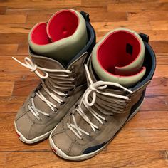 a pair of gray and red sneakers on wooden floor