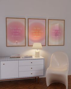 two posters on the wall next to a white chair