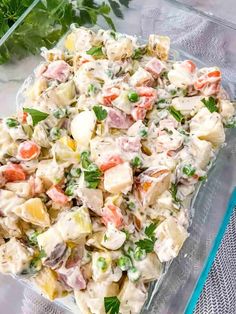 a glass dish filled with potato salad and garnished with parsley on the side