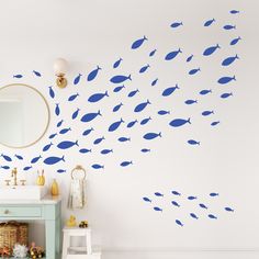 a bathroom with blue fish wall decals on the wall and a mirror above it